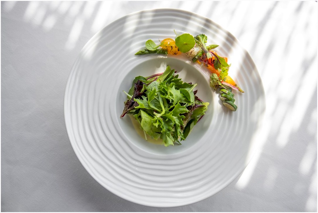 a white plate topped with a green salad