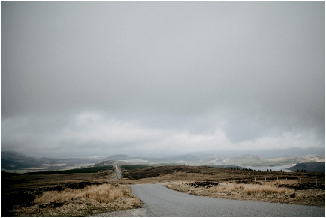 a road with grass and hills