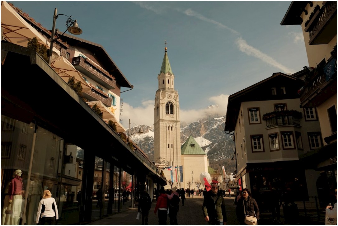 A european town street with a church and mountains.